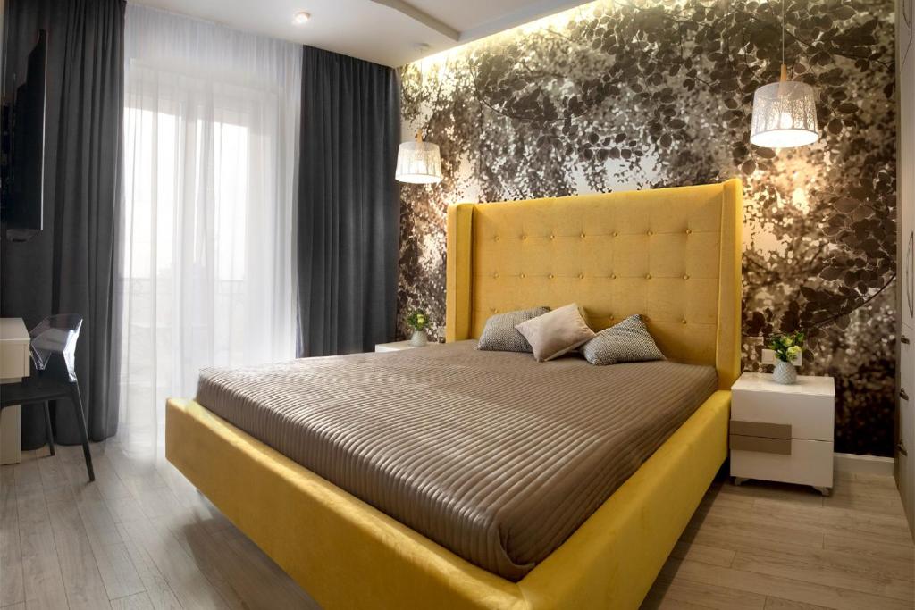 a bedroom with a yellow bed with a yellow headboard at Sunny Belle Apartments in Odesa
