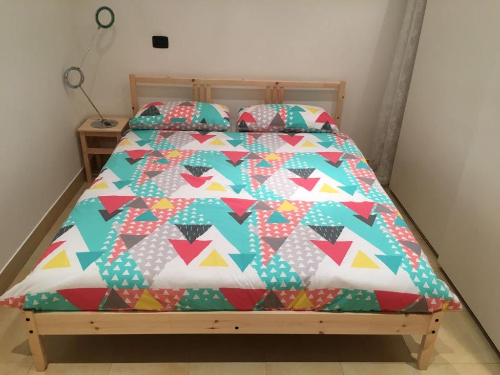 un letto con piumone e cuscini colorati di Interno 2 Il giardino segreto CENTRO a Bari