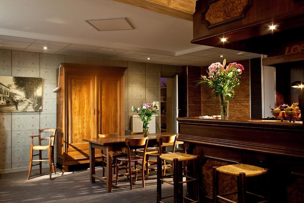 un restaurant avec une table, des chaises et un piano dans l'établissement Le Jardin de la Reyssouze, à Gorrevod