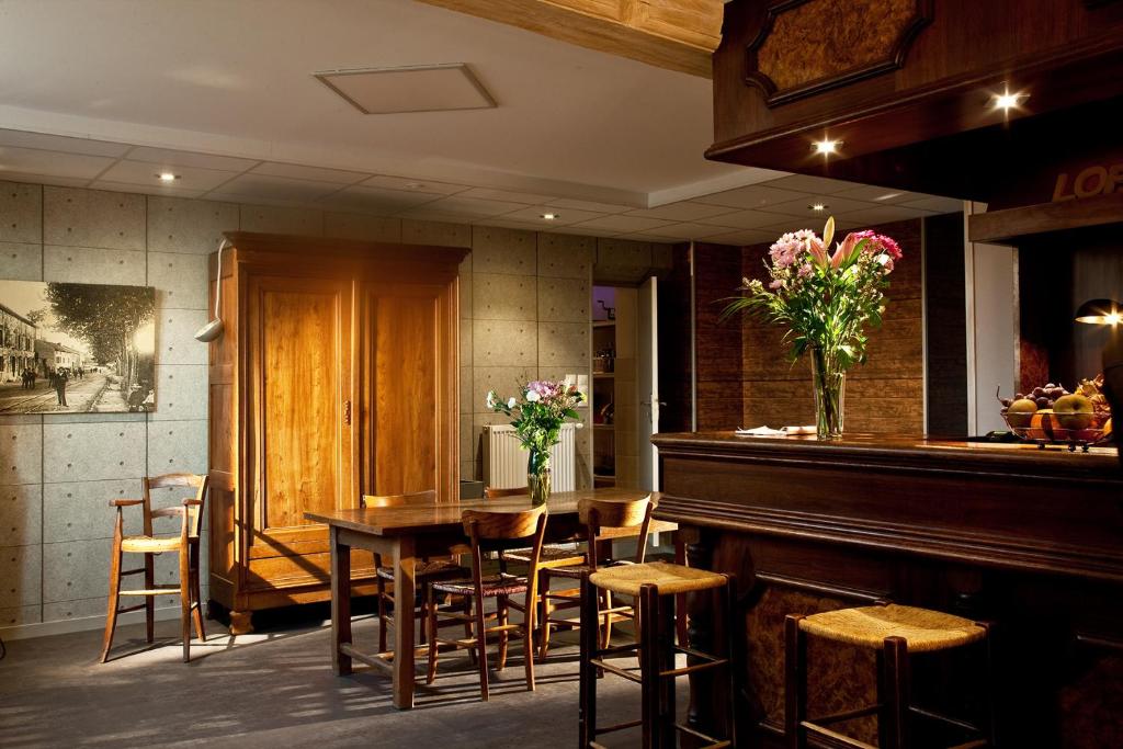 a restaurant with a table and chairs and a piano at Le Jardin de la Reyssouze in Gorrevod