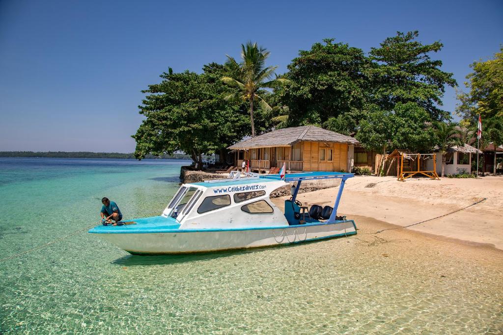 a boat sitting on the shore of a beach at Onong Resort in Bunaken
