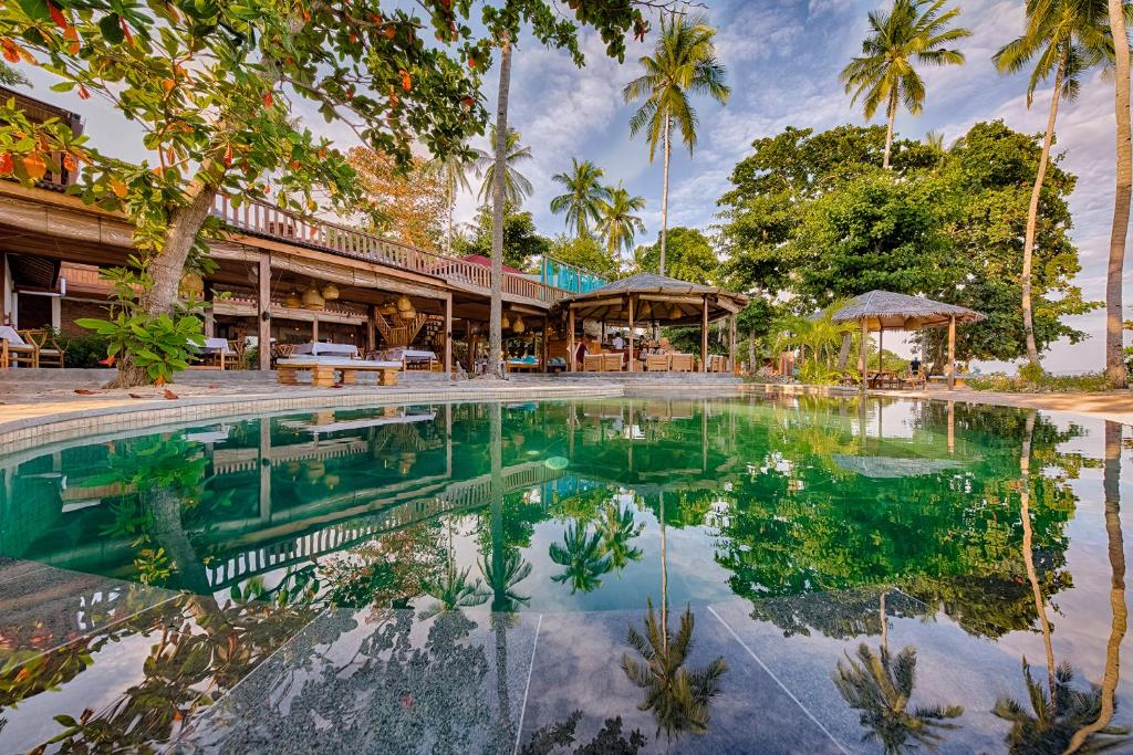 a pool at a resort with palm trees at Kuda Laut Boutique Dive Resort in Bunaken