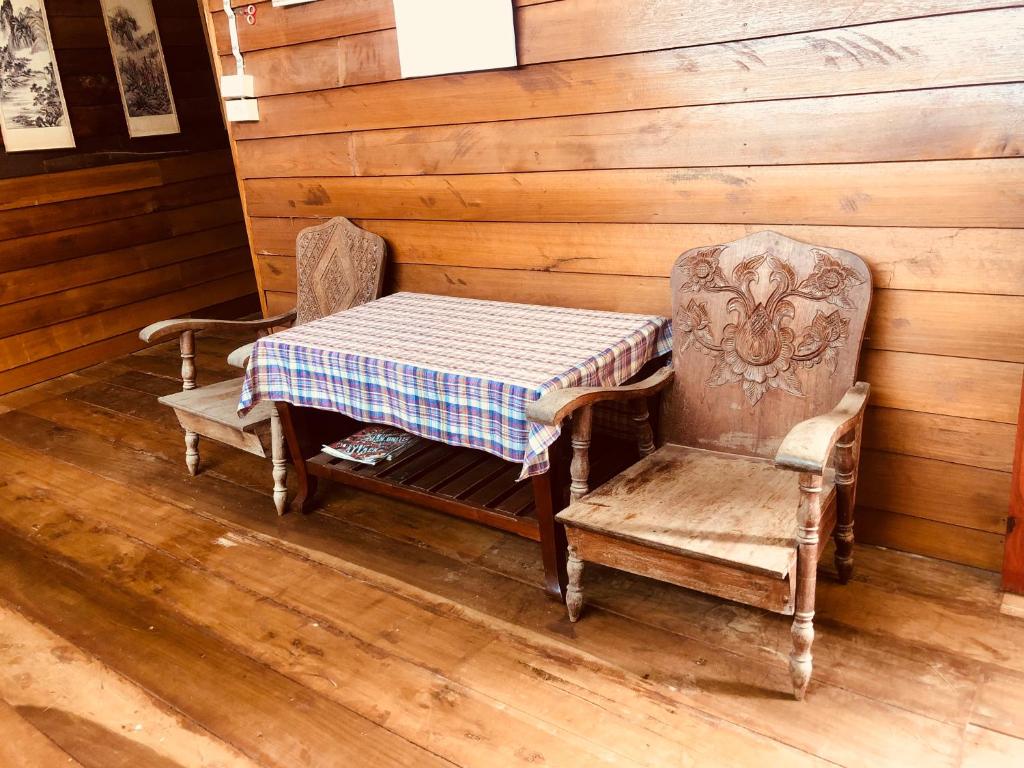 stół i 2 krzesła w pokoju ze stołem i stołem i krzesłami w obiekcie Huen Sabaidee Soi 8 w mieście Chiang Khan
