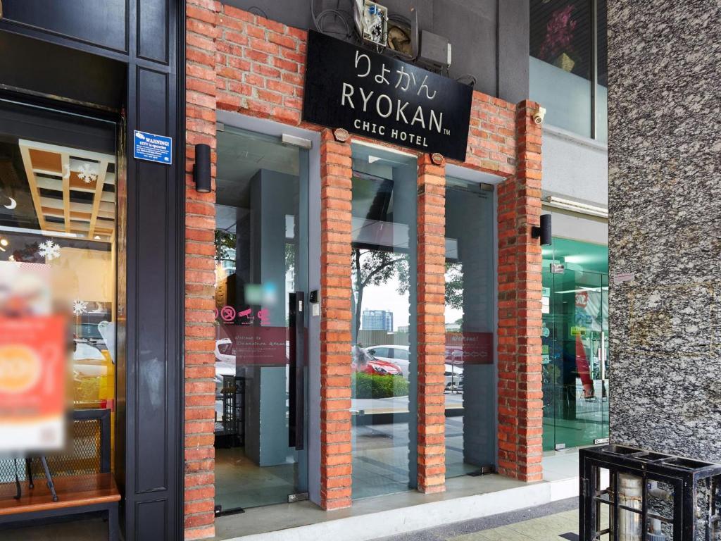 un magasin à l'avant d'un bâtiment en briques muni d'un panneau. dans l'établissement Ryokan Chic Hotel, à Petaling Jaya