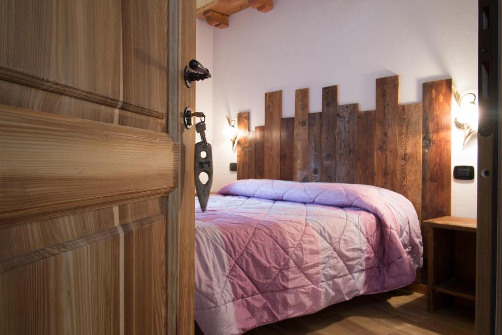 um quarto com uma cama e uma porta de madeira em B&B Lo VAN - Camere al Verde Villaggio di Rumiod em Saint-Pierre