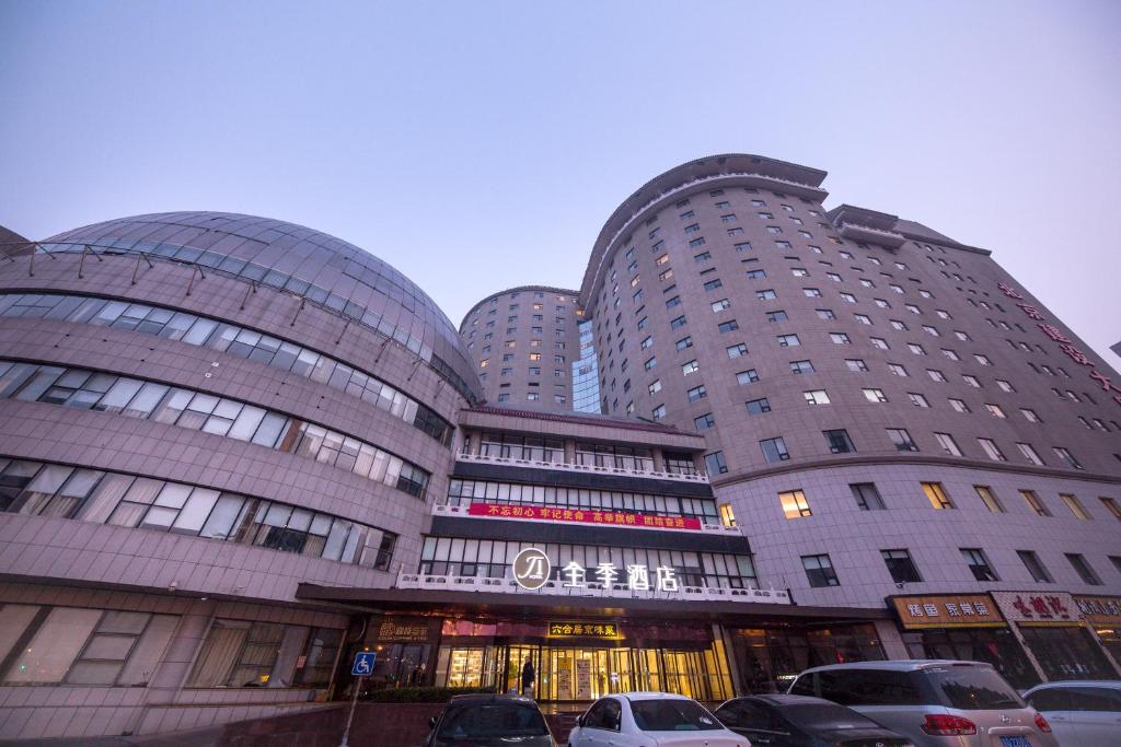 a large building with cars parked in front of it at JI Hotel Beijing West Railway Station South Square in Beijing