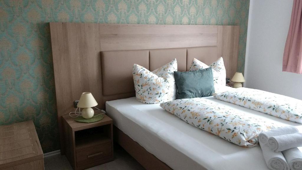 Un dormitorio con una cama con almohadas. en Hotel Pension Nordlicht, en Büsum