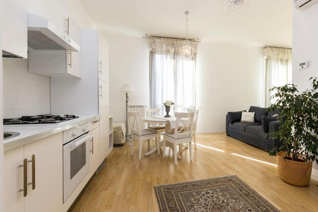 uma cozinha e sala de estar com uma mesa e um sofá em La Maison della piazzetta em Bolonha