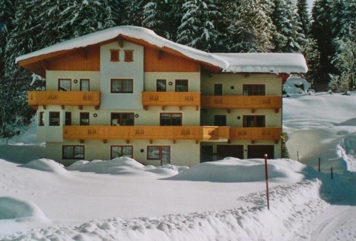 un gran edificio con nieve encima en Ferienwohnung Eberharter, en Finkenberg