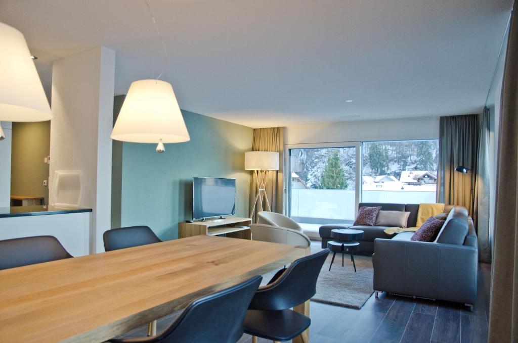 una sala de estar con una gran mesa de madera y sillas en Apartment Krokus - GriwaRent AG, en Interlaken