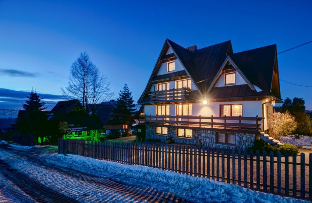 a large house with a fence in front of it at Pokoje gościnne "U Prusa" in Murzasichle