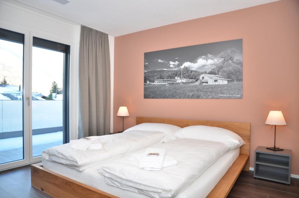 una camera con un grande letto e una grande finestra di Apartment Anemone - GriwaRent AG a Interlaken