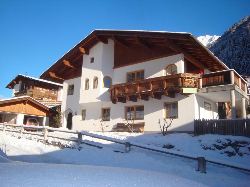 a house with a wooden roof in the snow at Alpenhaus Christian in Neustift im Stubaital