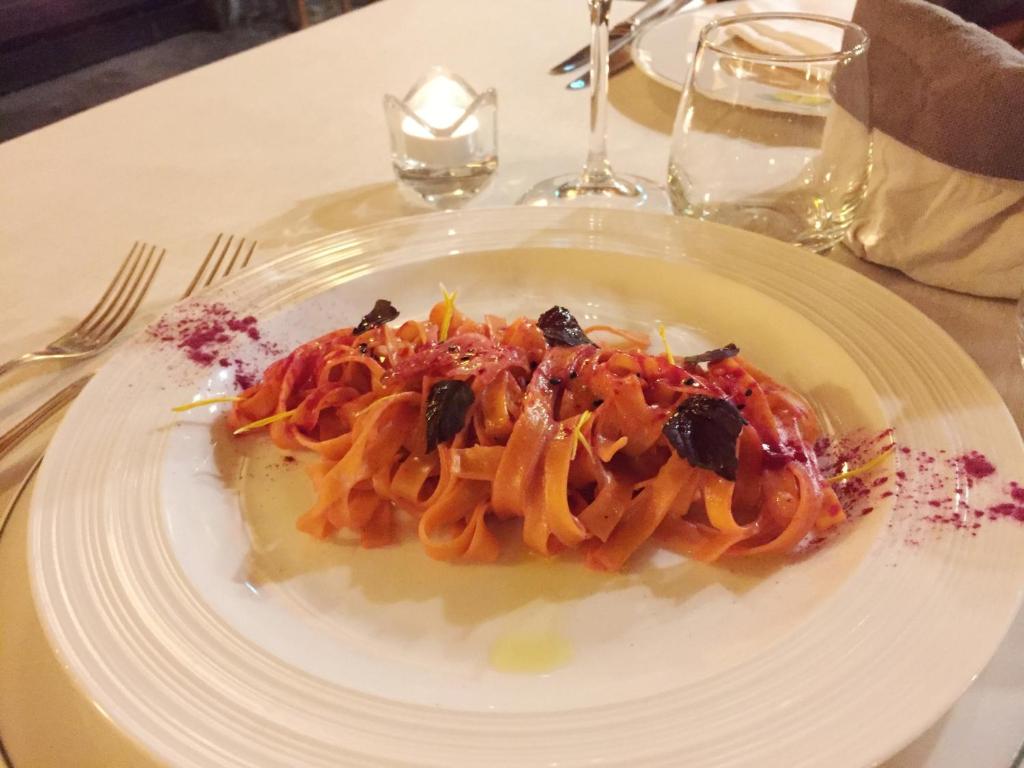 a white plate of pasta on a table at Le Rocher Hotel in Champoluc