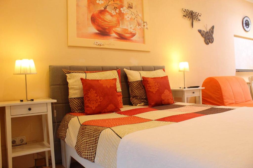 ein Schlafzimmer mit einem Bett mit orangefarbenen Kissen in der Unterkunft Tanja's B&B in Maastricht