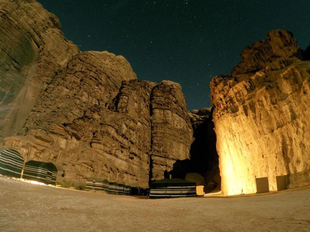 a rock wall at night with the lights on at Wadi Rum Nature Tours And Camp in Wadi Rum