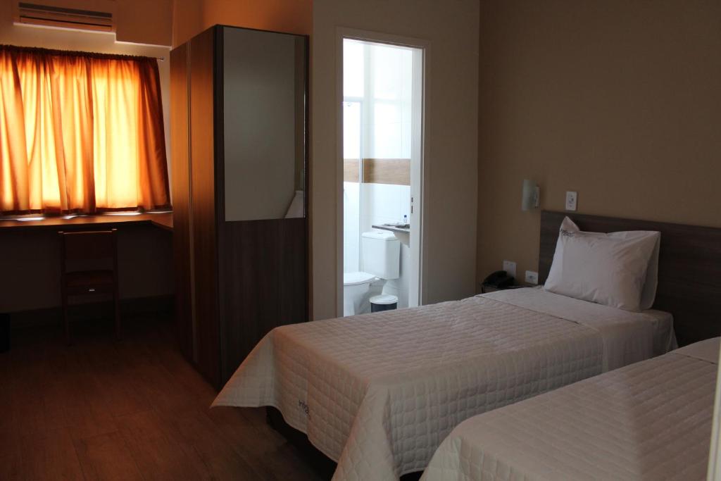 een hotelkamer met 2 bedden en een raam bij Hotel Infinity in Mauá