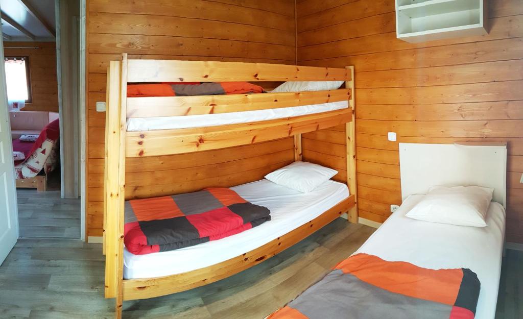Chalets du Lac في Arcizans-Avant: غرفة نوم مع سريرين بطابقين في كابينة