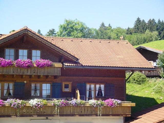 dom z balkonem z kwiatami w obiekcie Am Sonnenhang w mieście Immenstadt im Allgäu