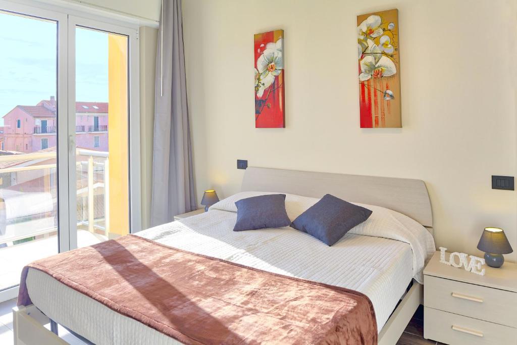 ディアーノ・マリーナにあるColibrì Apartments Diano Marinaのベッドルーム(ベッド1台付)、バルコニーが備わります。