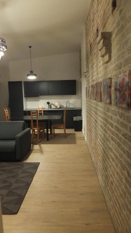 ein Wohnzimmer und eine Küche mit Ziegelwand in der Unterkunft Zentrale ruhige Ferienwohnung in Berlin in Berlin