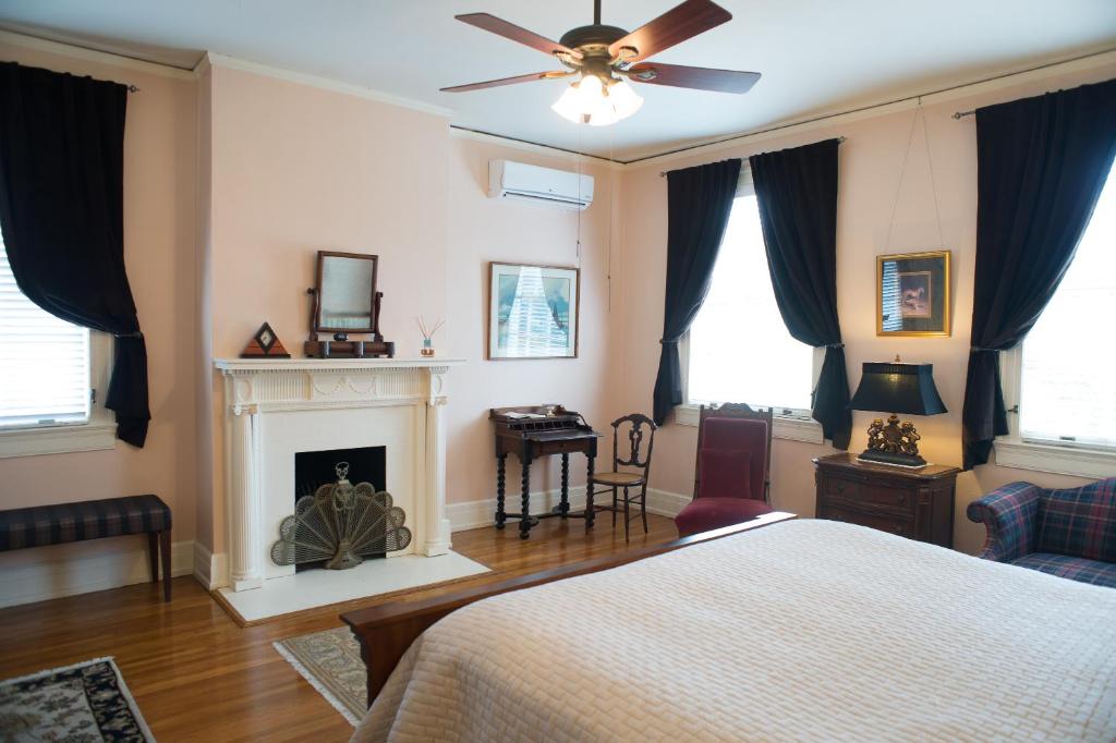 een slaapkamer met een bed en een open haard bij King George Inn in Roanoke