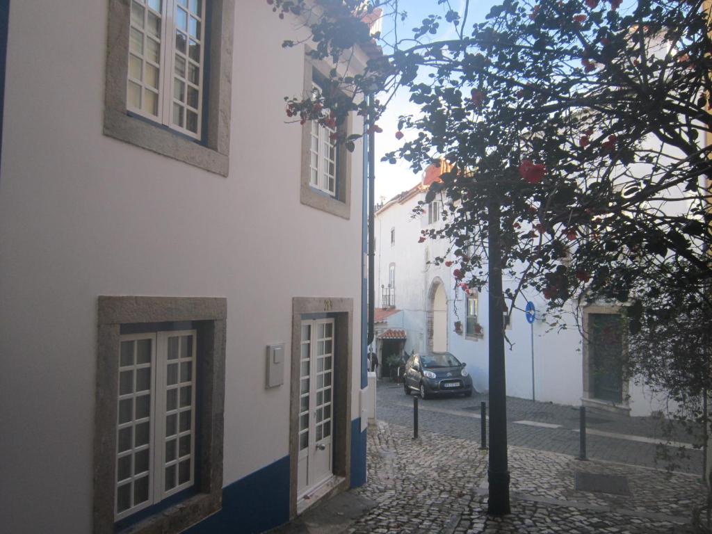 um edifício com portas e uma árvore ao lado de uma rua em Casa Zé Bonito II em Cascais