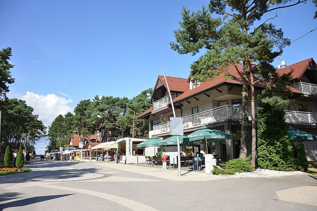 budynek ze stołami i parasolami na ulicy w obiekcie Pensjonat i Restauracja Laguna w Pogorzelicy