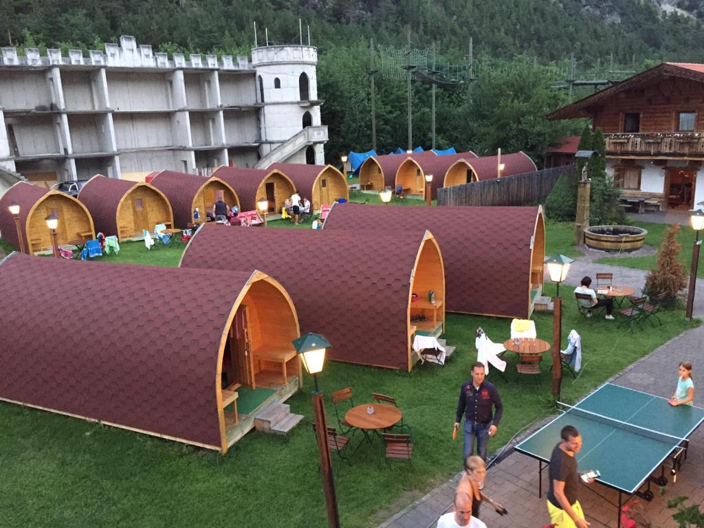 un grupo de edificios abovedados con gente jugando al tenis en Inn-side ADVENTURE CABINS, en Haiming