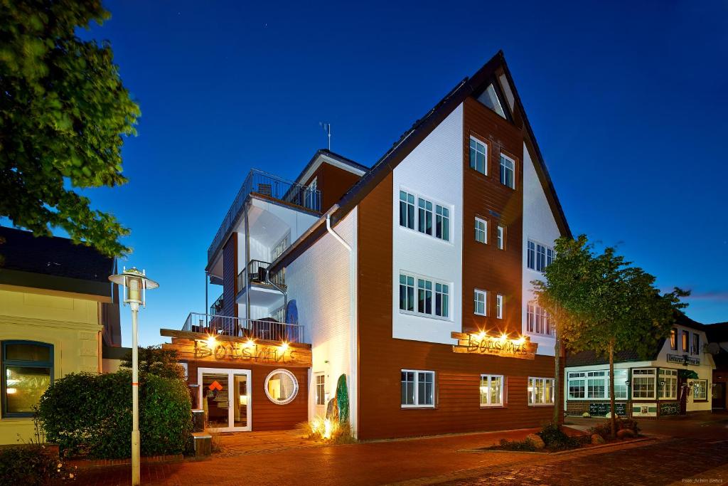 ein großes Backsteingebäude mit Nachtbeleuchtung in der Unterkunft Bernstein-Hotel Bootshaus in Büsum