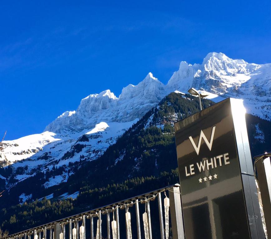 a sign in front of a snow covered mountain at Hôtel Le White - Le 42 Restaurant in Champéry
