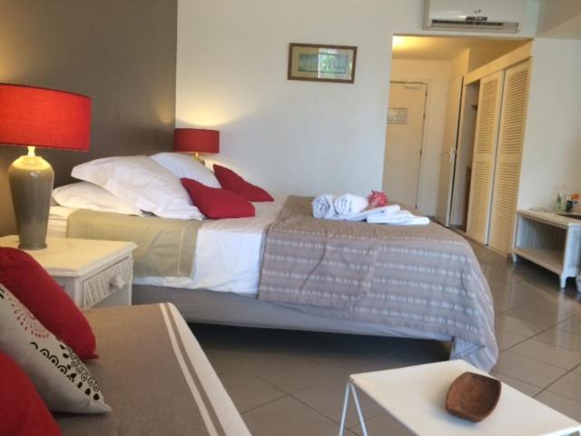 a bedroom with a large bed with red pillows at Studio Luxe vue mer in Le Gosier