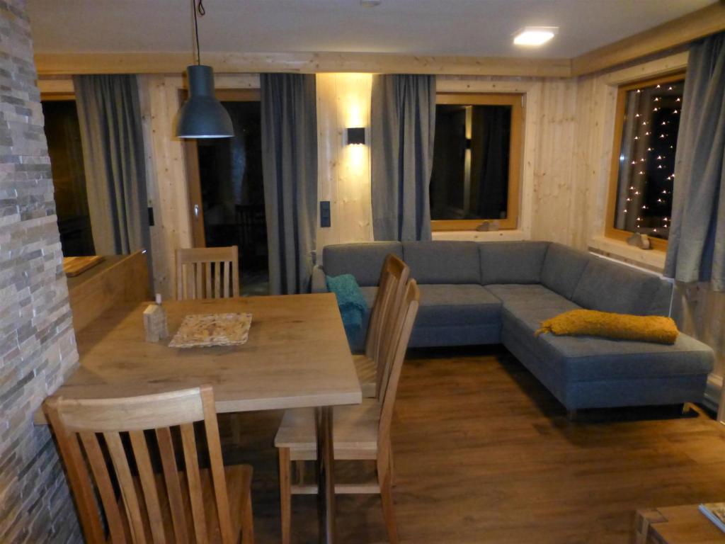 a living room with a blue couch and a table at Chalet Auszeit in Arzl im Pitztal