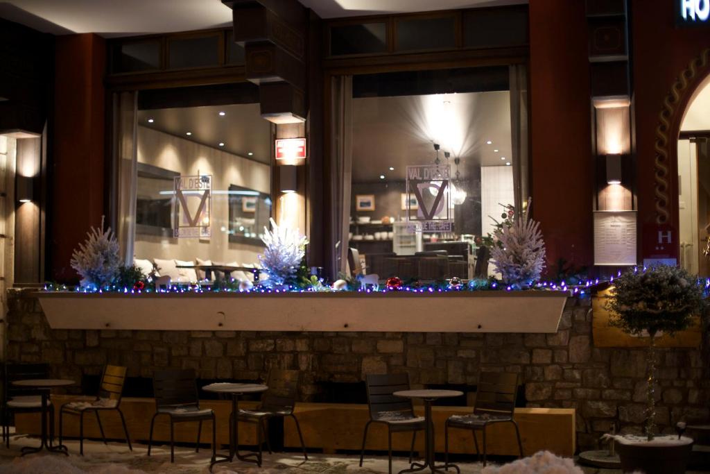 a restaurant with christmas lights and tables and chairs at Hôtel Val d'Este in Saint-Gervais-les-Bains