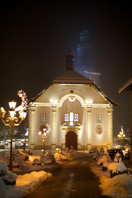 a large white church with lights in the snow at Hôtel Val d'Este in Saint-Gervais-les-Bains