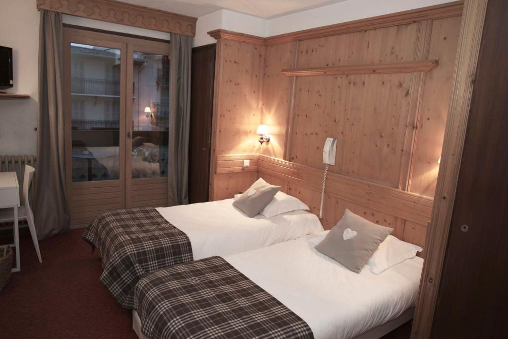 a hotel room with two beds and a telephone at Hôtel Val d'Este in Saint-Gervais-les-Bains