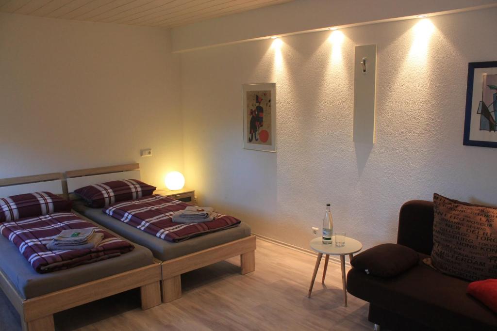 een slaapkamer met 2 bedden en een bank bij Ferienwohnung in Grenzach in Grenzach-Wyhlen