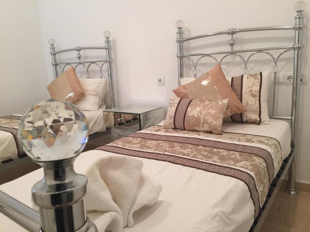 een slaapkamer met een metalen bed met kussens bij 5* Presidential Villa - El Valle Golf Resort in Sucina