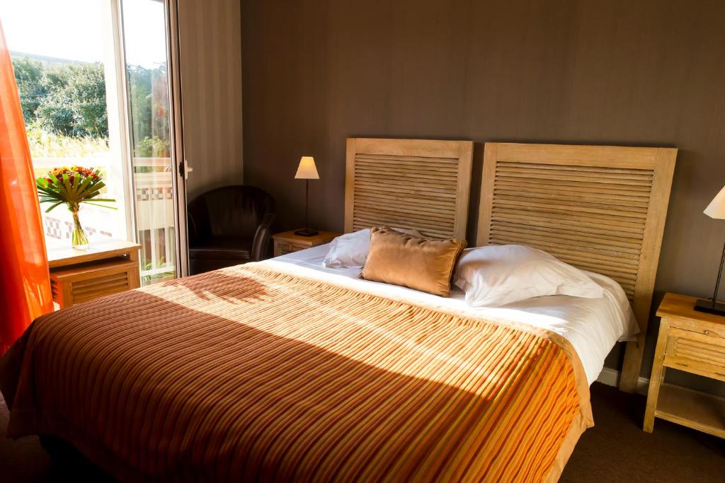 a bedroom with a large bed and a window at Almoria Hôtel & SPA in Deauville