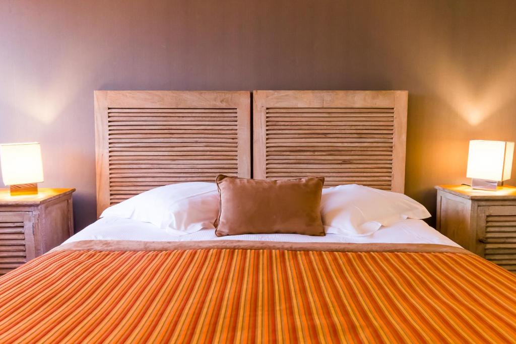 a bedroom with a large bed with two lamps at Almoria Hôtel & SPA in Deauville