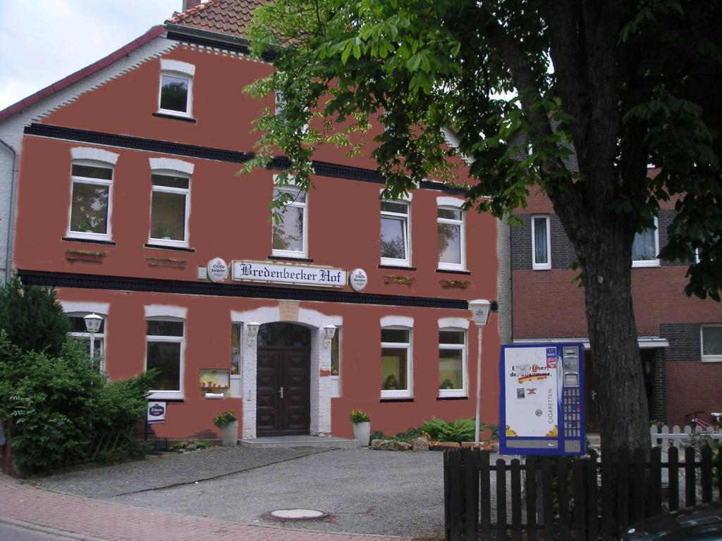 ein rotes Gebäude mit einem Schild davor in der Unterkunft Bredenbecker Hof in Wennigsen