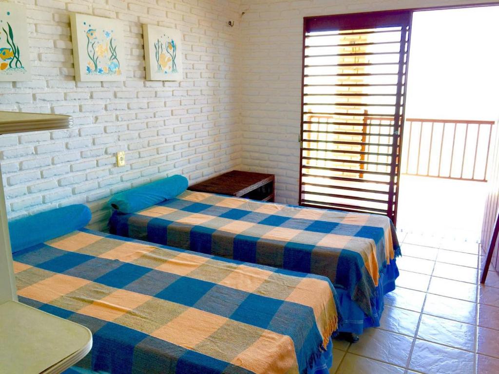 um quarto com duas camas e uma janela em Casa triplex Lagoinha em Lagoinha