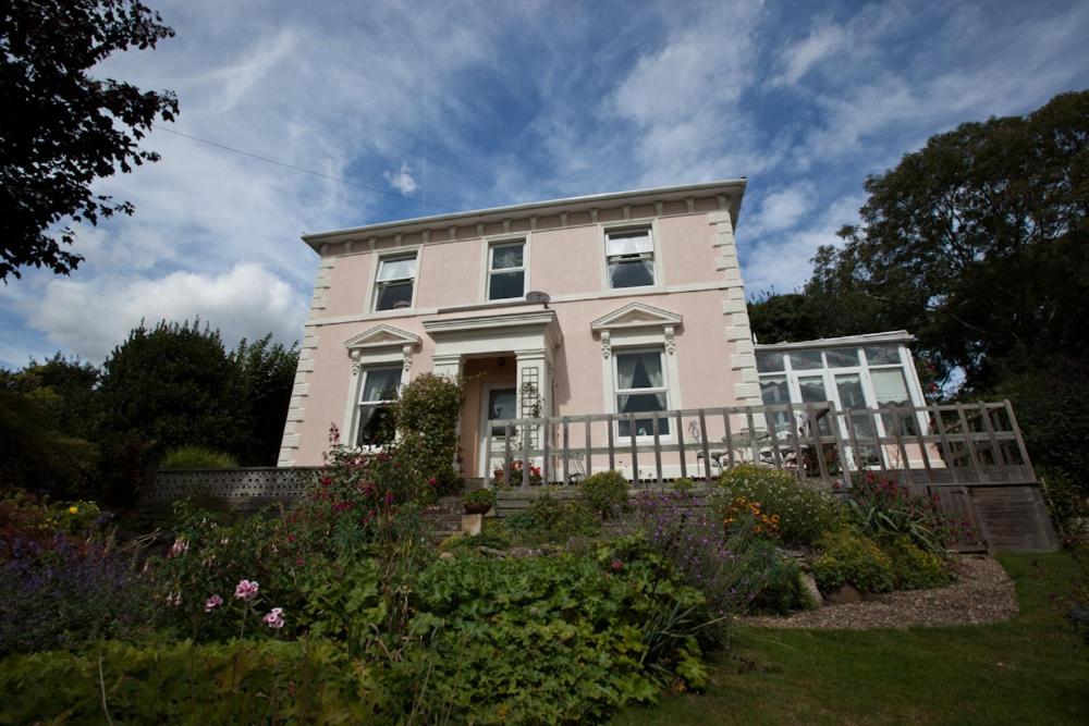 a white house with a garden in front of it at Sunny Bank Guest House in Hythe