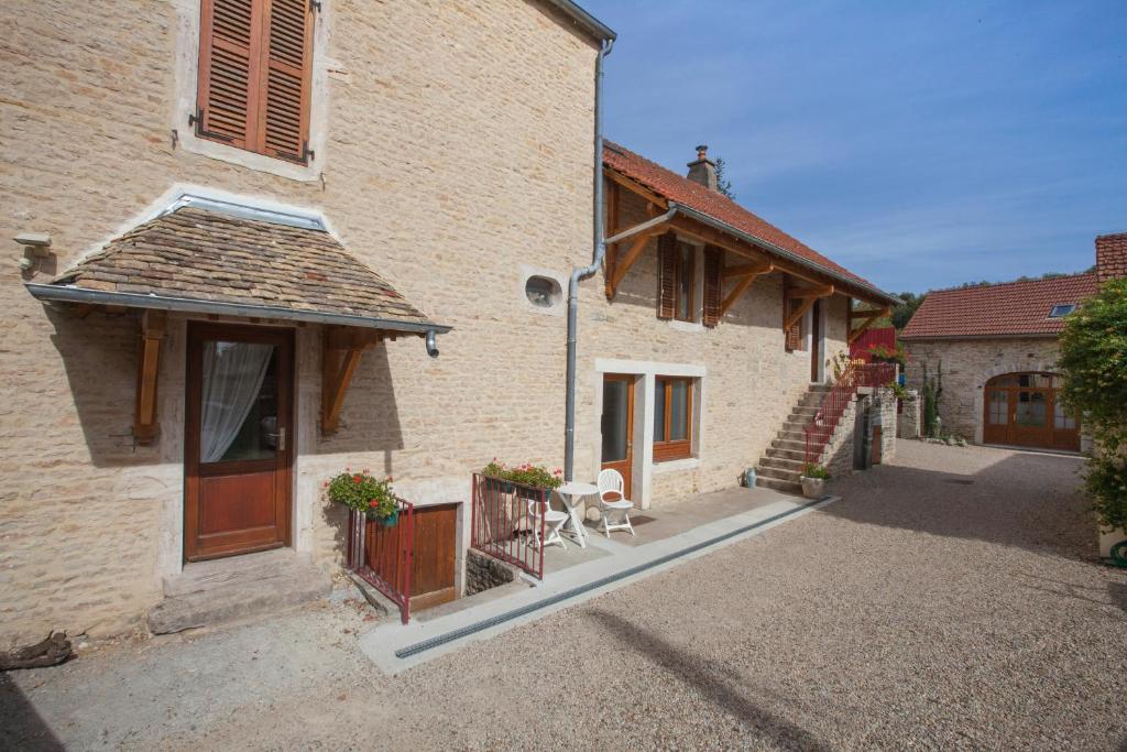 a large brick building with a porch and a patio at Le Mariecalou in Meloisey