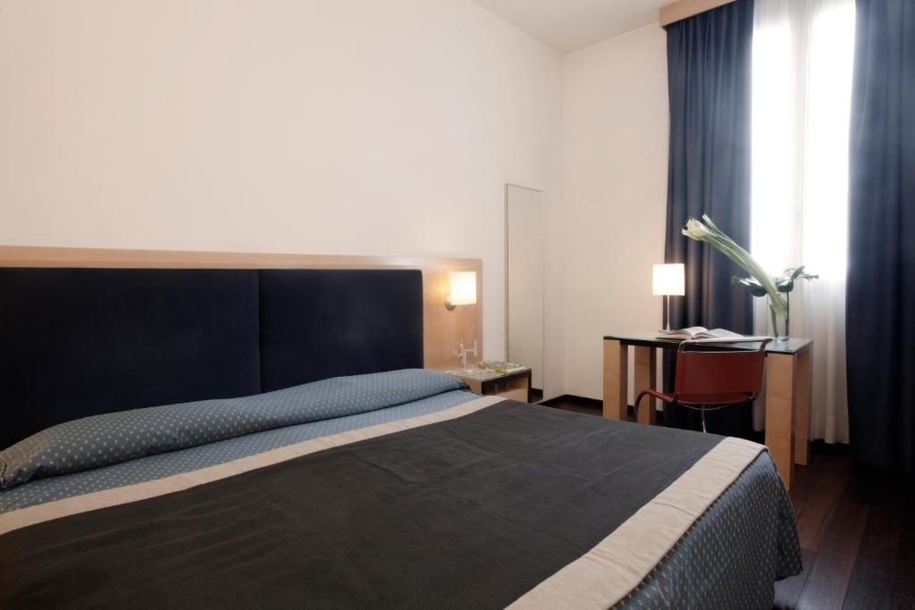 A bed or beds in a room at Hotel Grand'Italia