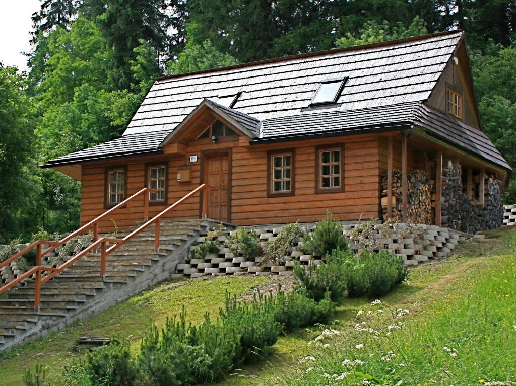 a log cabin with stairs leading up to it at Chata Krajinka in Ždiar