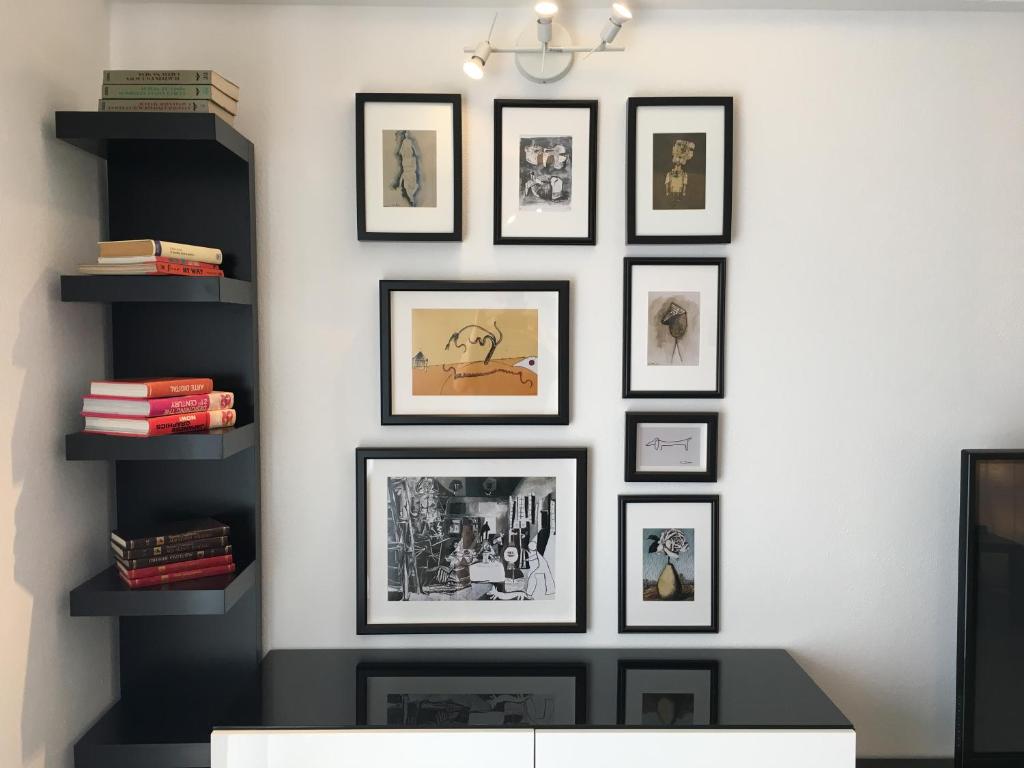 a wall with framed pictures on a wall at Casa da Fonte in Foz do Arelho