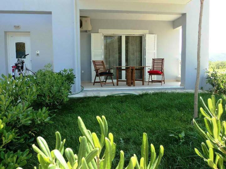 a house with two chairs and a table in the yard at Apartment with gardens (ideal for surfers) in Lefkada Town