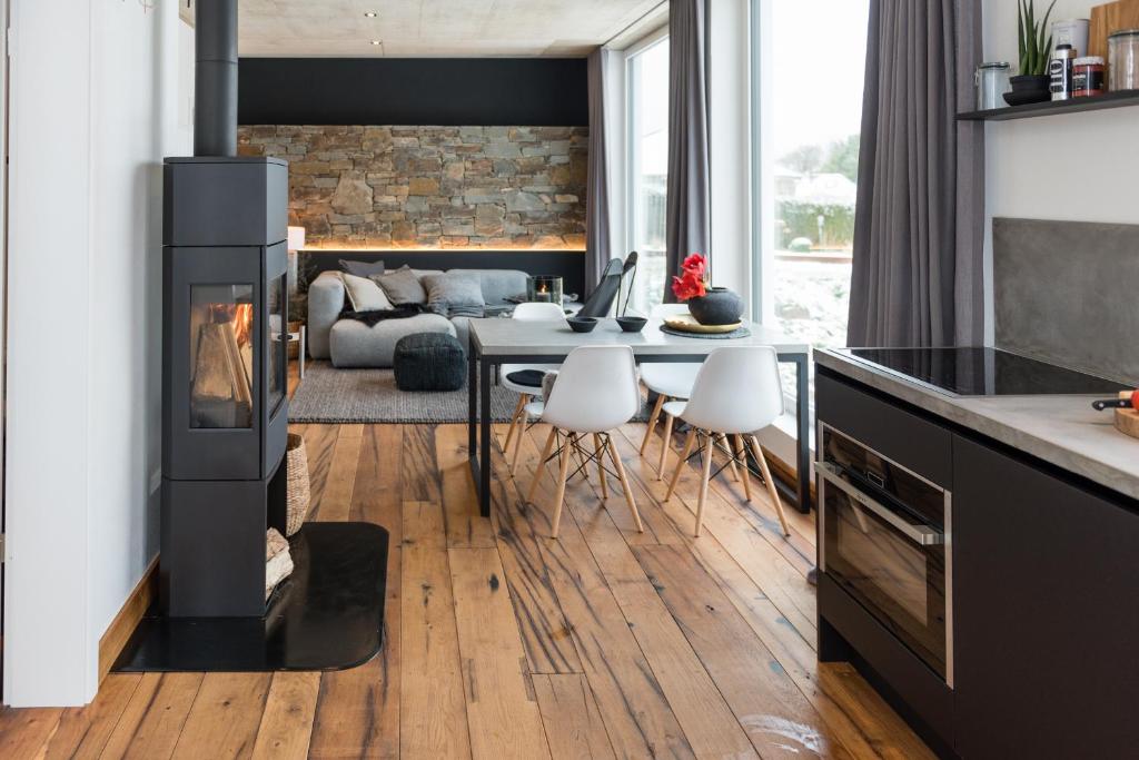 a kitchen and living room with a fireplace at N8Quartier Eifel in Bad Münstereifel