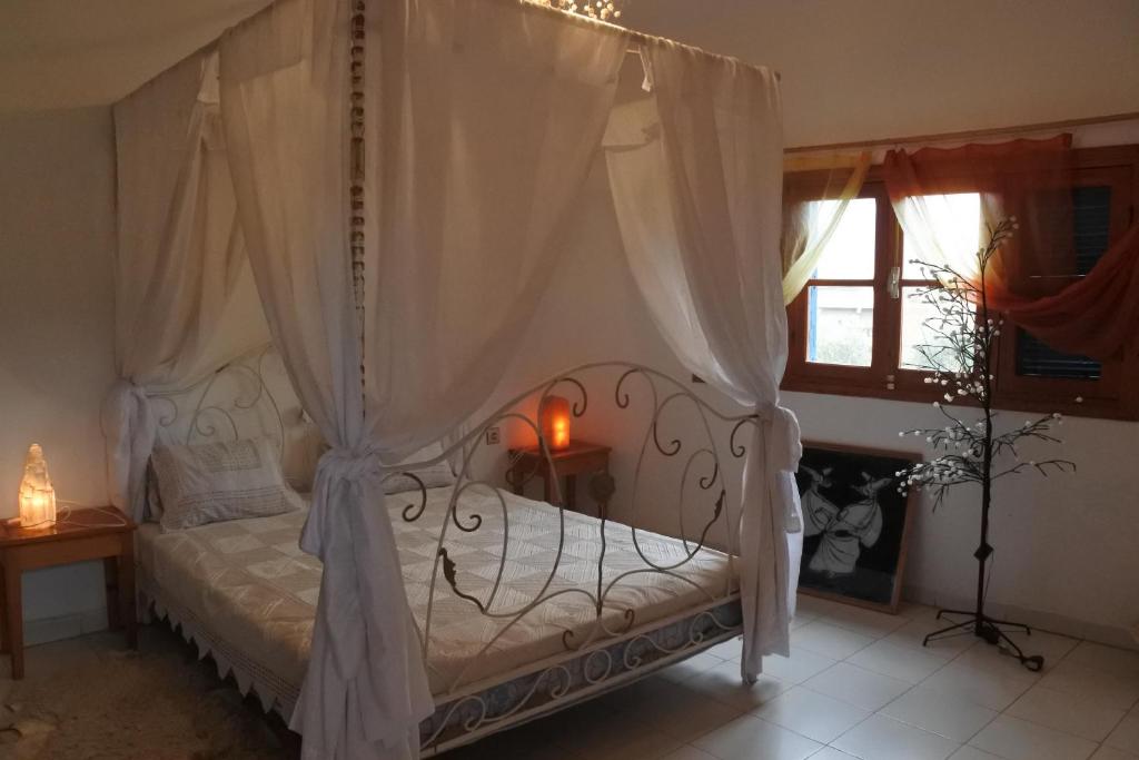 a bedroom with a bed with a canopy at Le jardin d'habiba in Rhorm el Alem